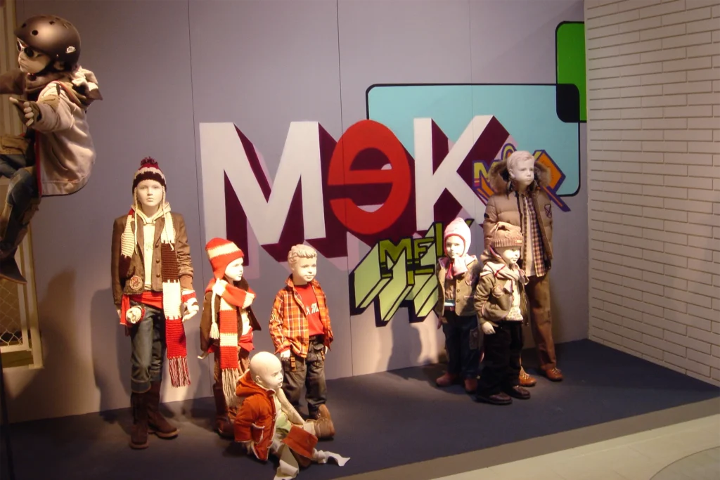 Allestimento moda bambini MEK con graffiti e manichini su fondo grigio, Pitti Immagine 2005.