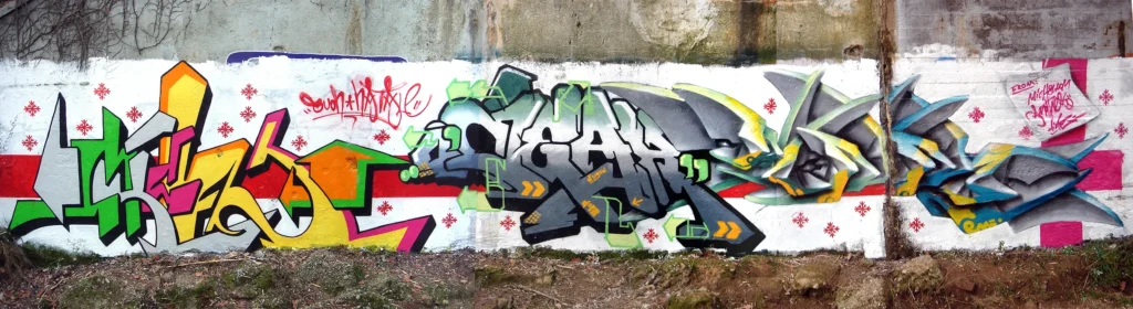 Muro completo con graffiti multicolori e lettering 3D, realizzato a Tradate nel 2005.