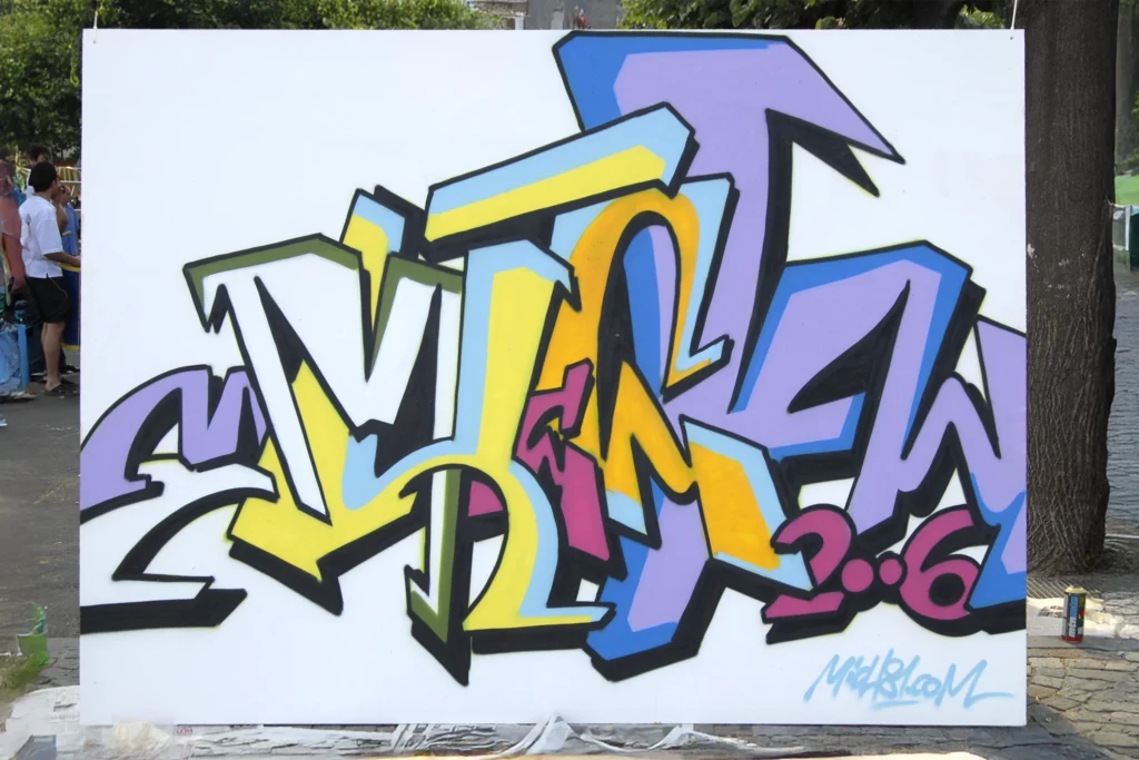 Graffiti colorato con lettering tridimensionale su pannello bianco, realizzato ad Arona nel 2006.