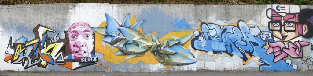 Ampio muro con graffiti e personaggi realistici, Borgo Ticino 2006.