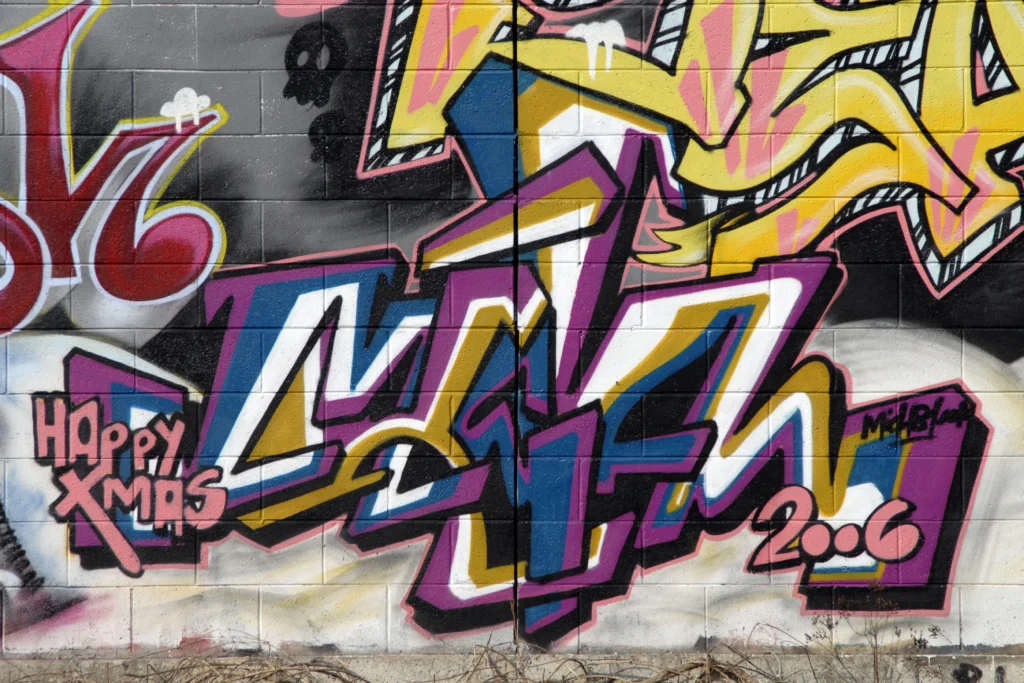 Graffiti su muro in blocchi di cemento con scritta “Happy Xmas”, Busto Arsizio 2006.