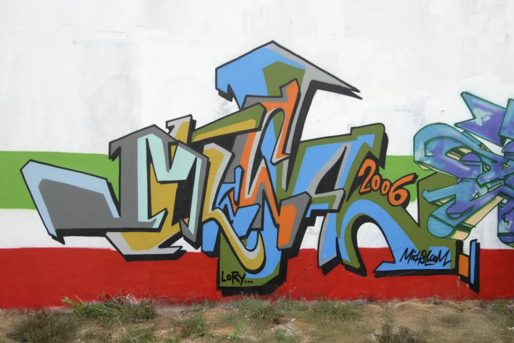 Graffiti tridimensionale dai colori vivaci su muro industriale, firmato Mich81, Busto Arsizio 2006.