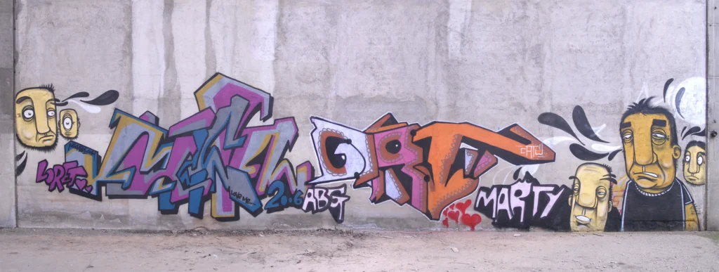 Murale con graffiti colorati e personaggi stilizzati su muro grezzo, Cairate 2006.