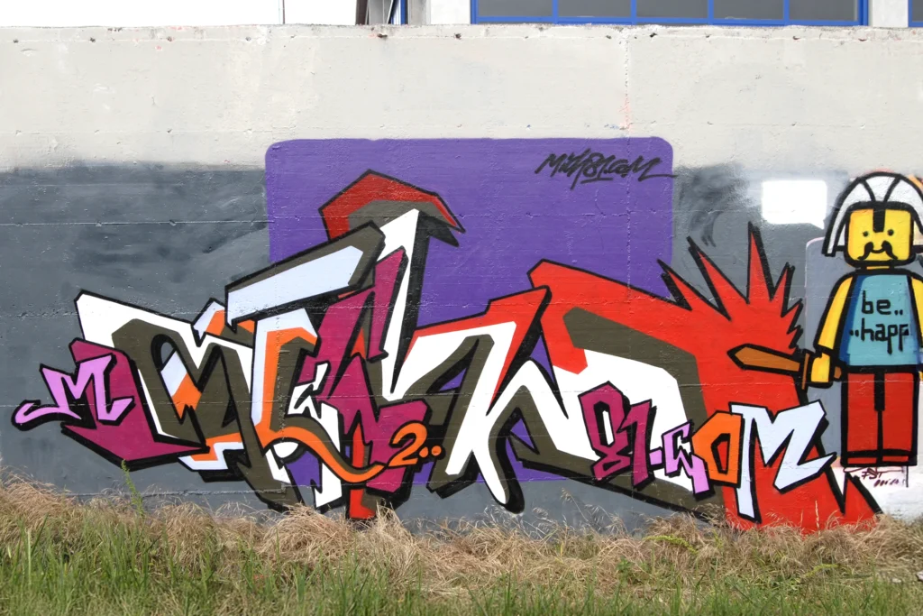 Murale con graffiti multicolori e personaggio cartoon, firmato Mich81, Castellanza 2006.