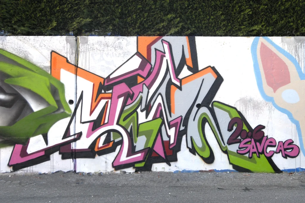 Graffiti in verde, viola e arancio su muro bianco con linee fluide, Sesto Calende 2006.